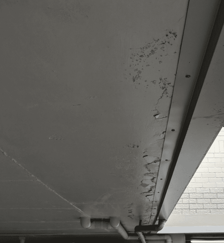 Gutter-and-signs-of-spalling-concrete on concrete slab edge
